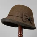 Detail van elegante wollen cloche hoed met contrastrand en decoratieve strik aan de zijde - M / 56-58cm / koffiekleur