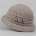 Detailed close-up of soft faux fur texture and elegant floral pearls on pink winter hat - Khaki
