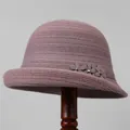Detail of knitted bucket hat featuring three elegant fabric flowers with inset rhinestones - M (56-58cm) / Taro