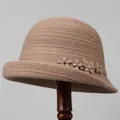 Dettaglio di un cappello lavorato a maglia kaki con fiore in rilievo e cristallo - M (56-58cm) / Rosa antico