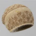 Detail of oatmeal knit beanie featuring fluffy squirrel wool and a gold S2 metal ornament - One Size Stretchy / Rice Camel