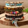 Detail of bohemian layered bracelets featuring wood beads, turquoise, and silver charms - Cattle Horn Crushed Stone Style