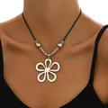 Détail du collier fleur évidée en argent avec cordon noir et accents de cœur - Style Fleur