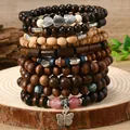 Macro shot of bohemian wood beads with heart charms and tree of life pendant on a wood base - Heart Butterfly Style