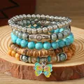 Detalle macro de pulsera multicapa con cuentas de turquesa y un colgante de mariposa - Diseño de Mariposa