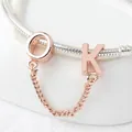 Makro-Detail von rosévergoldeten OK-Buchstabenanhängern an einem silbernen Armband - Roségold