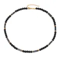 Collana vintage da uomo con pietre nere opache ed elementi dorati su sfondo bianco - Howlite a Linee Nere