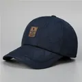 Detail einer dunkelblauen Stepp-Schirmmütze mit Rautenmuster und braunem Lederpatch - Verstellbar / Marineblau