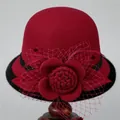 Detail of wool cloche hat with floral mesh veil and feather on a display stand - M (56-58cm) / Burgundy