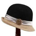 Detail view of woven cloche hat with rhinestone flower decoration and ribbon trim - M (56-58cm) / Black