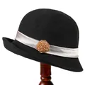 Vintage zwarte gebreide cloche hoed met zilveren lint en kralenbloem op een houten voet - M / Zwart