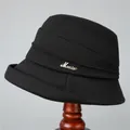 Close-up of black wool bucket hat featuring tiered pleats and a metal music badge - M (56-58cm) / Black