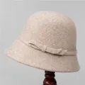 Detail view of oatmeal wool cloche hat with ribbon bow on a wooden stand - M (56-58cm) / Beige
