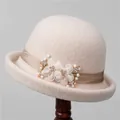 Elegante wollen cloche hoed voor dames met champagne zijden bloemen en parelaccents - M (56-58cm) / Broken Wit