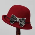Detail of burgundy wool cloche hat with a large rhinestone-studded bow decoration - M (56-58cm) / Ancorra Red