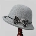 Detail eines grauen Wollhutes mit einer Strass-Schleife und schwarzem Band - M / Grau