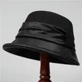 Detailopname van een elegante zwarte winteremmerhoed voor oudere dames op houten standaard - M / Zwart