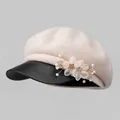 Detail van roze wollen baret met organza bloemen en zwarte lederen klep voor dames - M / Broken Wit