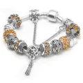 Bracciale argentato con ciondoli, cristalli arancioni e perle floreali traforate - 17 / Giallo