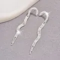 Primer plano de pendientes largos plateados con borlas de cristal y diseño de ondas - Plateado