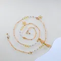 Detail van kralen brillenkoord met parels, gouden bloembedeltjes en champagne kwastjes - Gele Stijl (D) / Geel