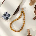 Detail van houten kralen telefoankoord op wit gevlochten hoesje met dennenappels - Gembergeel Vierkante Houten Kralen Stijl (Stijl B)