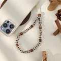 Detail van kralen telefoonkoord in aardetinten met houten cilinders en kralen - Zwart-wit Gestreepte Ronde Kralen Stijl (Stijl C)