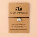 Détail du bracelet de voeux tressé avec pendentif panda sur carte en kraft - Panda