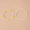 Detail of beaded bracelets set featuring white round beads and yellow flower patterns - White Daisy 2-Piece Set