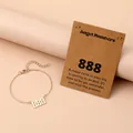 Close-up van gouden engel nummer 888 armband met geschenkkaart op zachte achtergrond - Nummer 888 / Goud