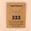 Vue macro du pendentif chiffre des anges 333 en acier argenté sur carte de message - 333