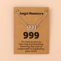 Detailweergave van de zilveren engel nummer 999 hanger op een kraft displaykaart - 999