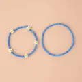 Détail d'un ensemble de bracelets bohèmes en perles bleues avec motifs de marguerites - Ensemble 2 pièces marguerite bleue