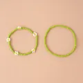 Détail de deux bracelets en perles vert herbe avec des motifs de marguerites blanches - Ensemble 2 pièces marguerite verte