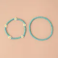 Détail d'un ensemble de bracelets en perles bleues avec de petites fleurs perlées - Ensemble 2 pièces marguerite bleu lac