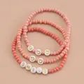 Pink bohemian beaded bracelets set featuring golden smile letters and heart charms - SMILE 3-Piece Set
