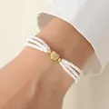 Three-layer white beaded bracelet featuring a golden heart pendant and metallic accents - Bracelet / White