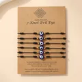 Set van 6 zwarte gevlochten boze oog armbanden met gouden kralen op display - Zwarte Collectie