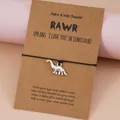 Bracelet de vœux tissé main avec pendentif dinosaure argenté et carte RAWR noire - Brachiosaure
