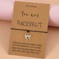 Bracelet tressé noir fait main avec breloque chat argentée sur carte cadeau kraft - Chat