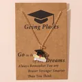 Collana di laurea dorata con tocco nero e pergamena su un biglietto regalo - Tocco Dottorale Testo Graduate