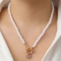 Witte parelketting met een gouden OT-sluiting en fonkelende letter M-hanger met stras - M