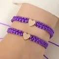 Adjustable purple braided rope bracelets featuring a polished golden heart-shaped charm - Set of 2 / Purple