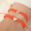 Two bright orange woven bracelets featuring polished golden heart charms for women - Set of 2 / Orange