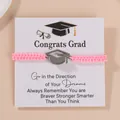 Braided pink graduation bracelet with silver mortarboard charm on display card - Pink