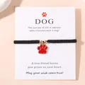 Handgemaakte zwarte gevlochten armband met rode hondenpoot hanger op witte kaart - Rood