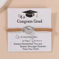 Braided gold graduation bracelet with stainless steel cap pendant on greeting card - Coffee