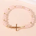 Elastische kralenarmband met roze kristallen kralen en gouden kruishanger - Roze