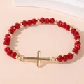 Elastische kralenarmband met rode facetkristallen en een gouden kruisvormige hanger - Rood