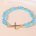 Elastic beaded bracelet with light blue crystal beads and a golden cross pendant - Blue